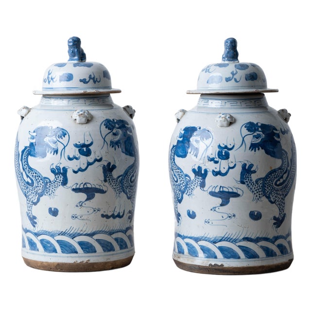 Pair of Chinese Blue and White Glazed Dragon Jars With Foo Dog Lid Finials For Sale