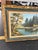 This is a vintage oil painting on canvas featuring a serene lakeside landscape with a dense forest. The double-layered...