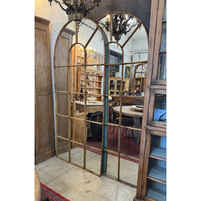 French iron window frame dating to circa 1890, professionally retrofitted with mirror glass. Featuring a graceful arched...
