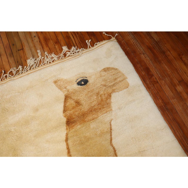 One of a kind large square room size with a happy-go-lucky large camel sitting on an ivory ground. The wool on this is...