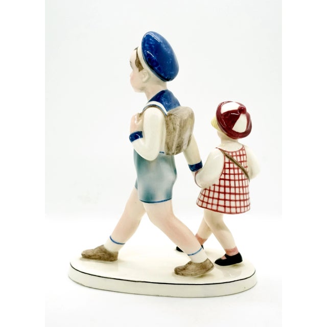 Especially rare goldscheider ceramic figurine group. Boy in sailor suit with shorts, long-sleeved top and sailor hat,...