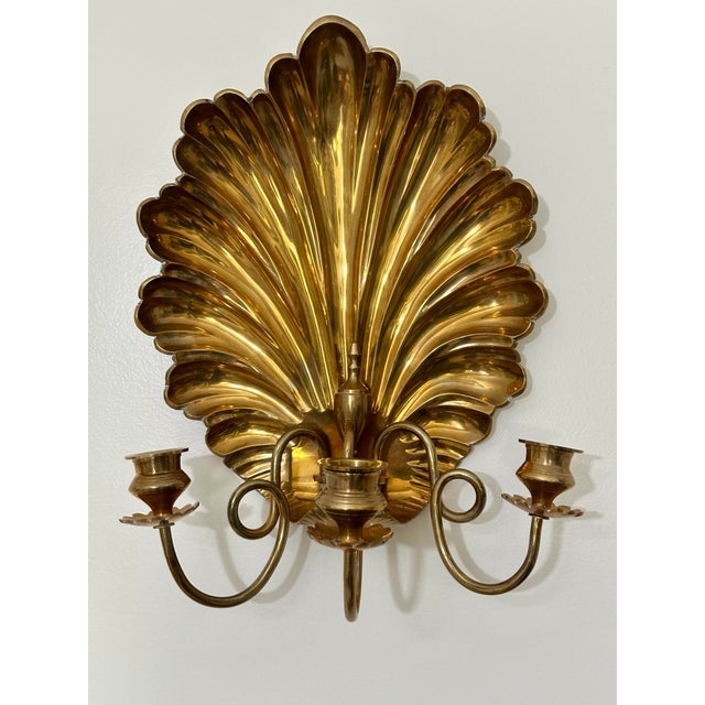 We are very pleased to offer a striking pair of vintage brass wall sconces, circa the 1980s. This pair features bold,...