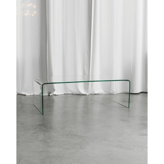 A timeless coffee table made of clear bent glass. Its transparent appearance lightens the space and fits perfectly into...