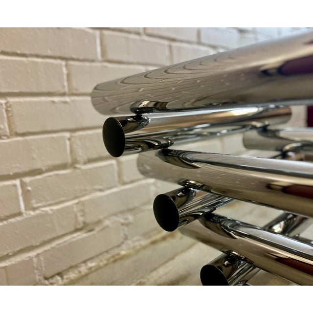 A striking vintage three-tier étagère in polished tubular chrome with smoked glass shelves, built in the cantilevered...