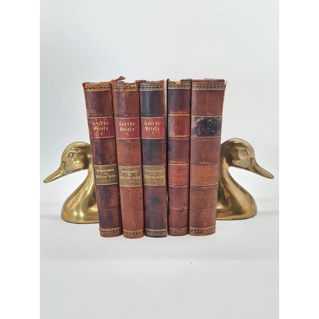 A pair of decorative brass bookends A unique pair of brass bookends shaped like stylized ducks, designed as a decorative...