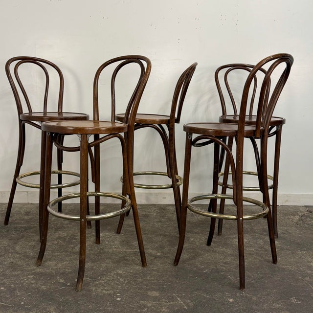 Set a five No. 18 barstools designed by Michael Thonet featuring a bentwood frame and metal foot rest.