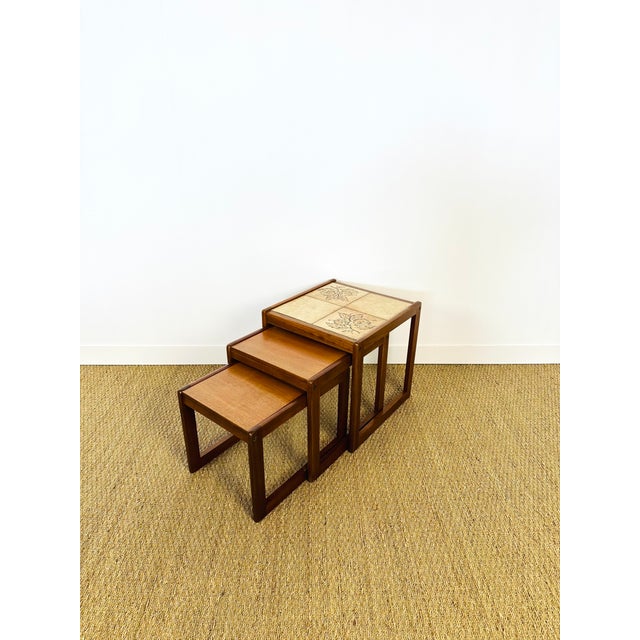 Teak and ceramic nesting coffee table dating from the sixties. made up of three tables. dimensions: h46 l44.5 d47 / h40...