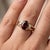 Embrace the deep, passionate warmth of this striking three-stone statement ring, beautifully combining vintage romance...
