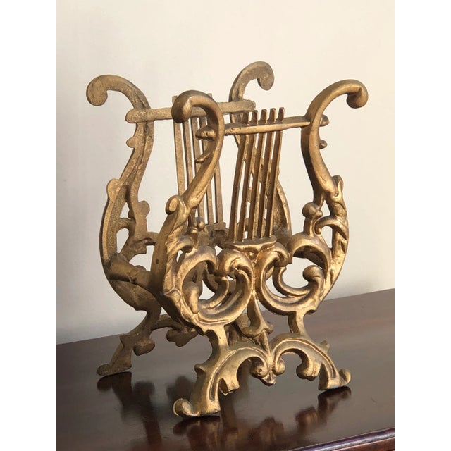 Vintage cast iron magazine / display stand with a baroque style lyre design. Has its original gold finish and is in every...