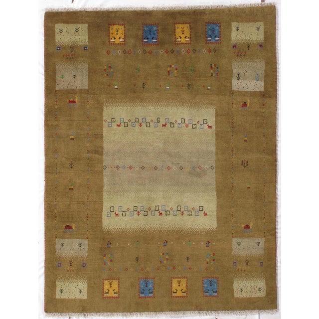 Hand-knotted Persian Lori Gabbeh rug featuring a warm brown field with a contrasting ivory central panel, framed by a wide...