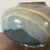 Large hand thrown studio pottery lidded jar featuring a flowing crystalline glaze in shades of gray, blue, and cream....