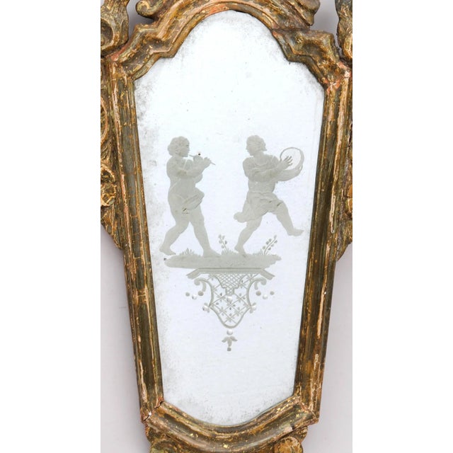 Venetian giltwood mirror with frame robustly carved with shell crest and both C-scroll and foliate borders enclosing a...