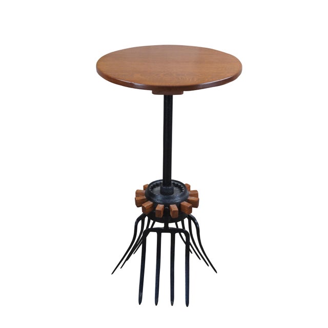 Late 20th Century industrial farmhouse bistro side or end table. Features an oak top over a cast iron wagon wheel and...