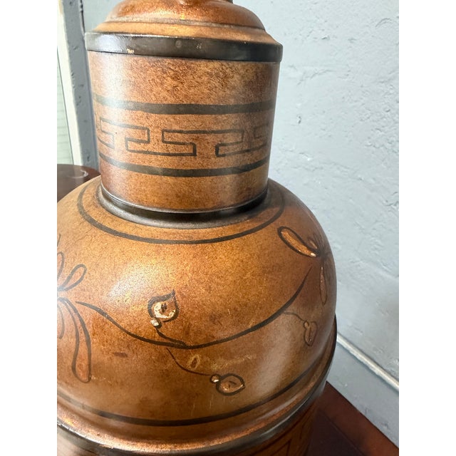 Striking vintage table lamp featuring a warm antiqued copper gold finish, intricate hand-painted Asian inspired figural...