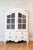A Swedish period Rococo painted wood cabinet with bonnet-shaped pediment, glass doors, lower drawers and original hardware...