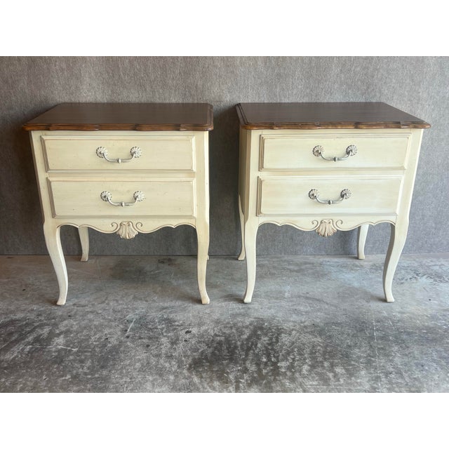 Pair of vintage Ethan Allen French Country two drawer nightstands with antique white painted sides and stained top....