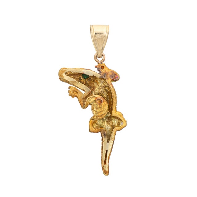 Finely detailed Alligator pendant crafted in 18 karat yellow gold. Two small estimated 0.01 carat emeralds are set into...