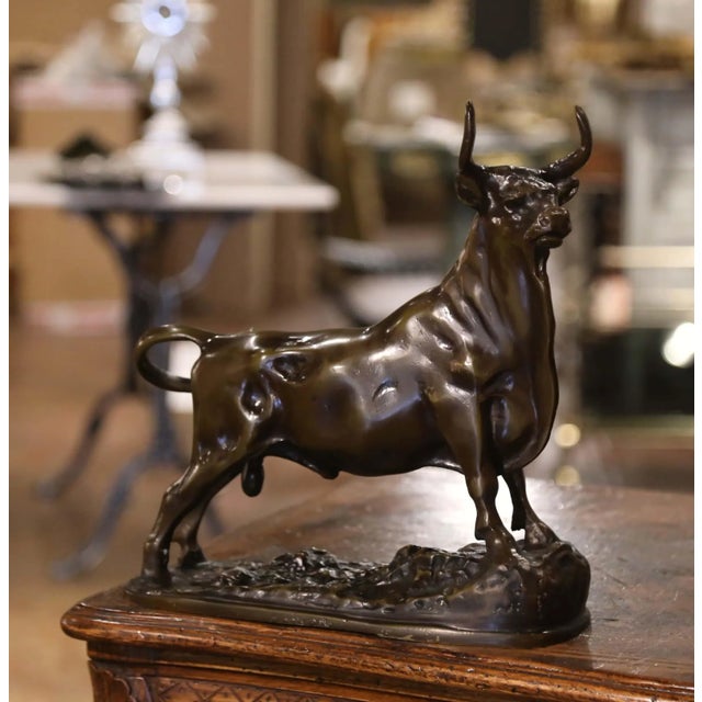Powerful in expression and finely modeled, this antique bronze sculpture depicts a muscular bull standing proudly in an...