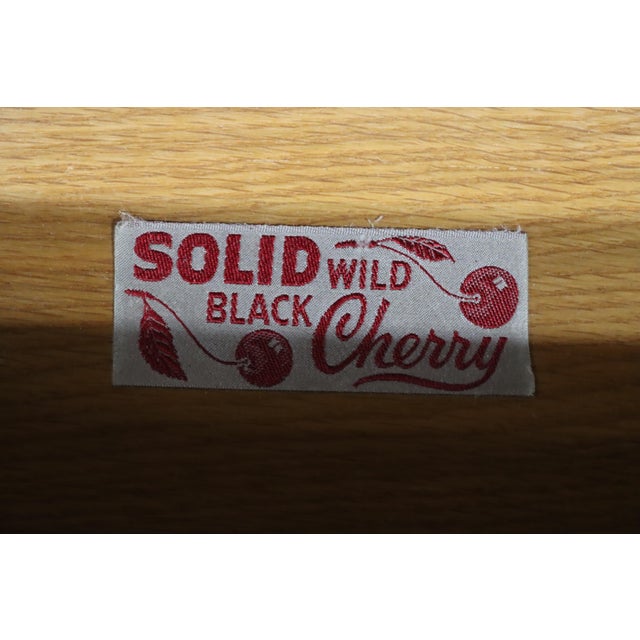 Pair of solid wild black cherry nightstands by Henkel Harris. Each features an upper open shelf, two drawers with brass...