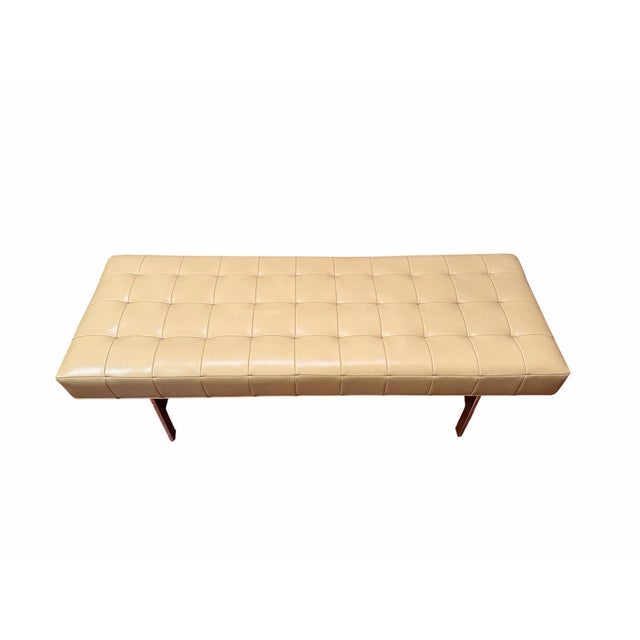 A substantial 1960s mid-century modern bench attributed to Knoll, featuring a generously proportioned tufted vinyl cushion...
