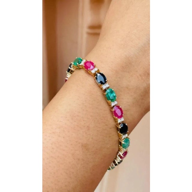 This Glamorous Emerald, Ruby and Sapphire Tennis Bracelet with Diamonds in 14K gold showcases 18 endlessly sparkling...