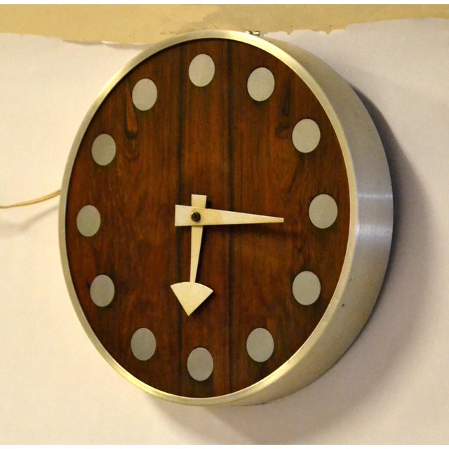 This 1970s mid-century modern wall clock, designed by Arthur Umanoff for Howard Miller, features a striking Zebra Wood...