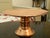 A elegant hand hammered copper pedestal cake stand featuring an authentic, elegant design. Its circular tray rests on a...