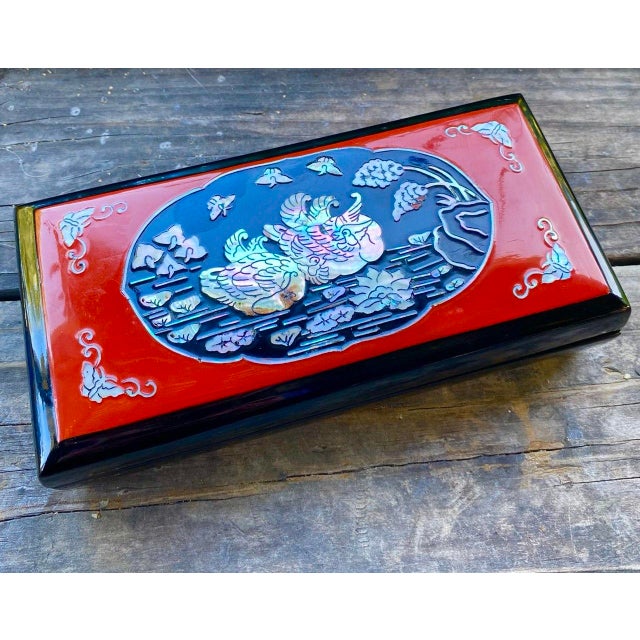 A striking mid-century Japanese lacquer smoking box or decorative table accessory featuring dramatic red and black...