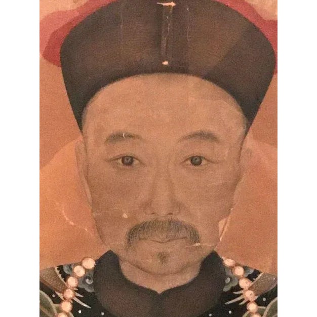 This is a Qing Dynasty (1644-1911) ancestor portrait. Ancestors were usually shown in their best dress, which gives us a...