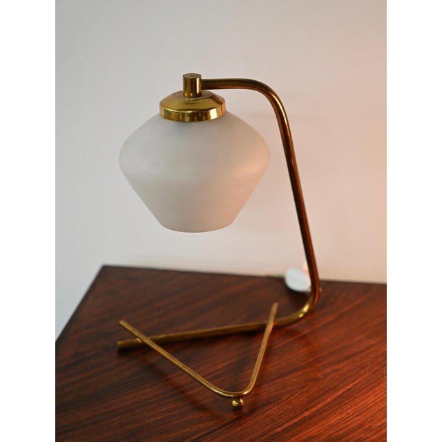 Marvelous pair of table lamps in brass and opaline glass. These incredibly elegant and unique table lamps were designed by...