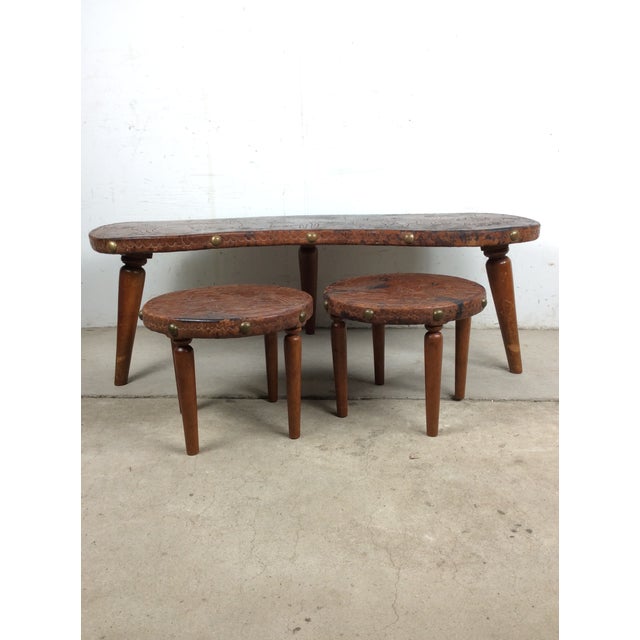 This mid century coffee table features hardwood construction, kidney bean shape with embossed leather top featuring rural...
