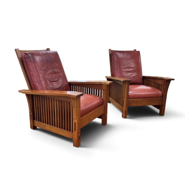 A pair of vintage Stickley Spindle Leather Morris Chairs. The forerunner of the modern recliner and is part of the 1989...
