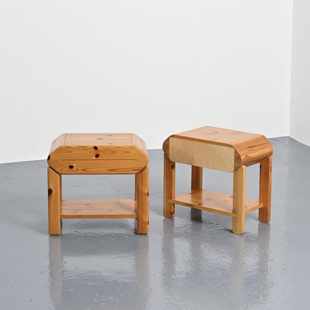 Pair of solid pine bedside tables produced by Maison Regain in France, circa 1970. Each bedside table features a compact...