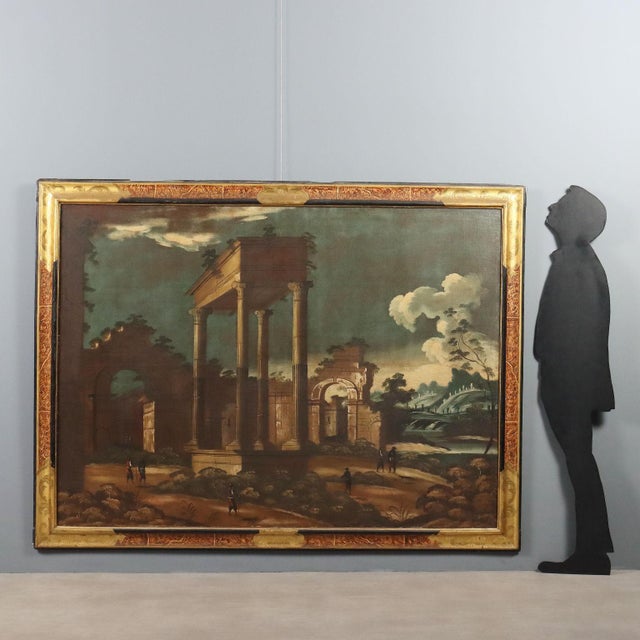 Oil on canvas. A large architectural capriccio featuring the remains of a fragment of a classical temple colonnade, rising...
