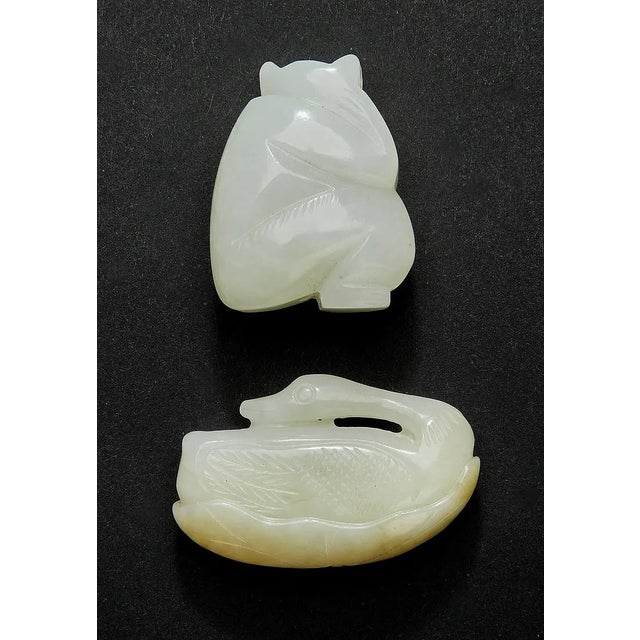 A fine quality set of 2 Chinese celedon jade carvings. The first depicts a seated figure, 1.5"h x 1.25"w and the second is...