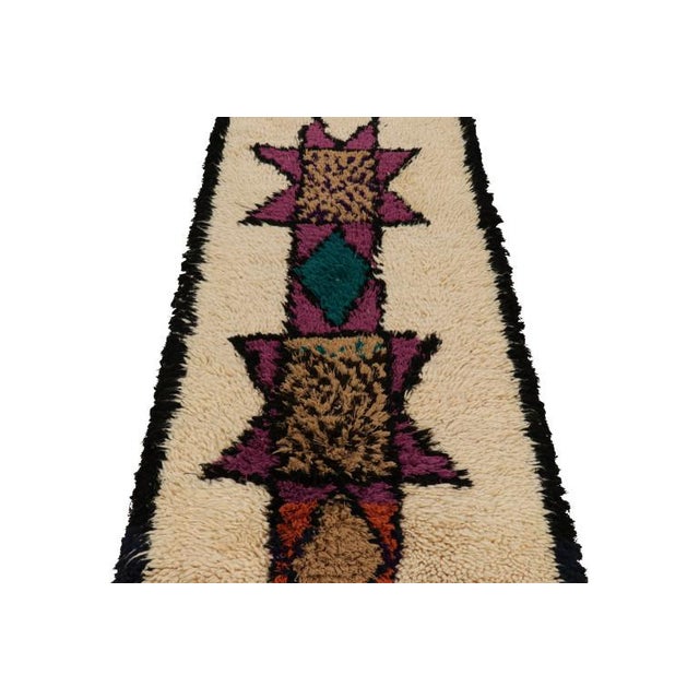 Hand-knotted in wool and originating from Morocco circa 1950-1960, this 3x6 vintage Moroccan rug is an extremely rare...