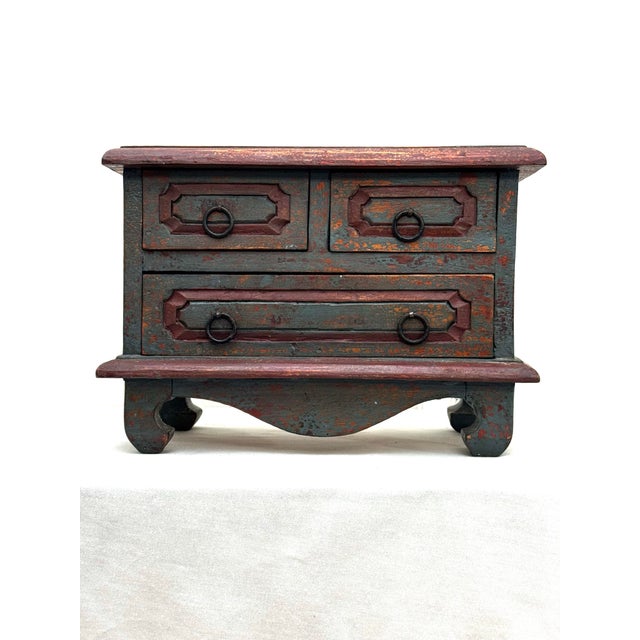 This vintage small apothecary chest exudes character from its distressed painted finish, petite metal ring handled etched...