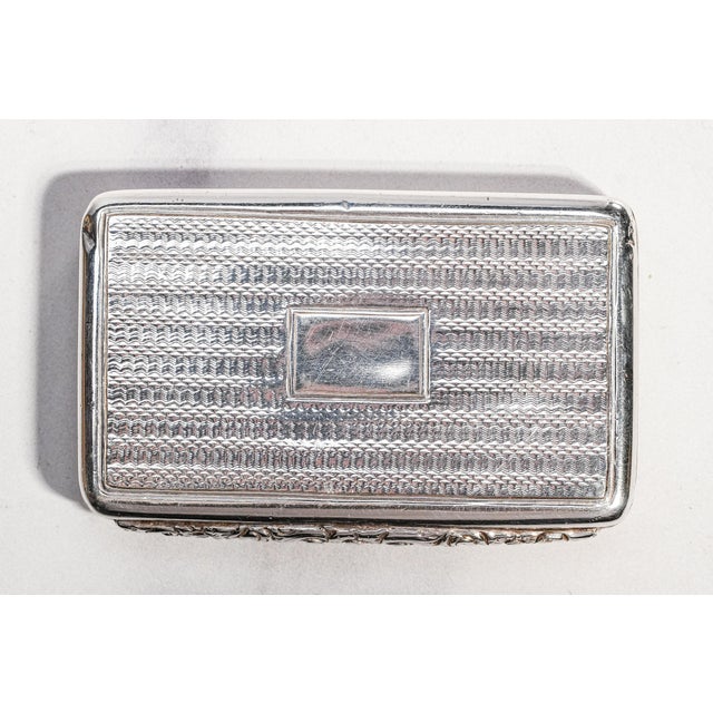 A refined and deeply personal example of early 19th-century English silver, this antique sterling silver snuff box...