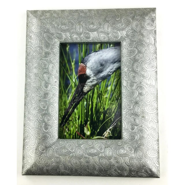 A beautiful design on this frame. Heavy carved silver tone covered ceramic frame with a wire holder. The back shows as if...