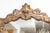 This is an elegant Italian Rococo-style wall mirror featuring a richly carved giltwood frame with exuberant scrolling...