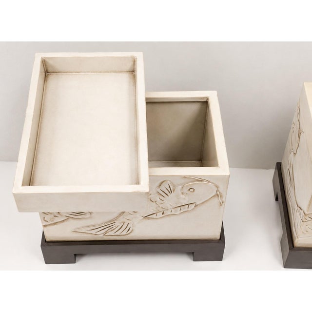 This is a pair of mid-century Asian modern side tables with carved koi fish throughout both body and lid. They are painted...