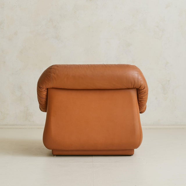 An Italian lounge chair from the 1960s, upholstered in supple cognac leather and generously padded with foam. Its...