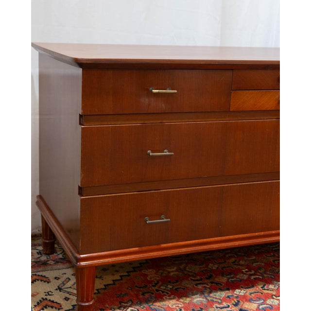 A petite Danish chest of drawers in the Art Deco tradition, produced in the 1950s with carved legs and original brass...