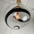 A striking contemporary pendant light featuring a large handblown smoked glass globe accented b a dramatic black spiral...