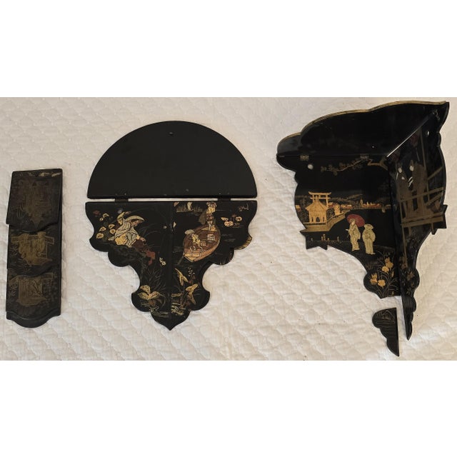 A distinctive 19th century chinoiserie black lacquer ensemble comprising shaped wall pockets, shelves, and a coordinating...
