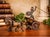 A striking vintage bronze sculpture depicting a Roman warrior standing in a two-wheeled chariot drawn by two horses....