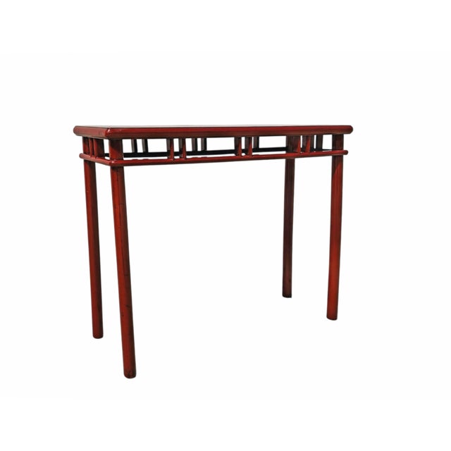 This a contemporary, slender console table features a vibrant, high-gloss red lacquer finish. The design includes a flush...