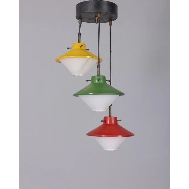 Three-light pendant chandelier with colored glass lampshades. The lampshades are entirely made of glass. Designed by...