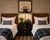 A refined pair of vintage twin headboards by Henredon featuring richly toned walnut veneers accented with brass campaign-...