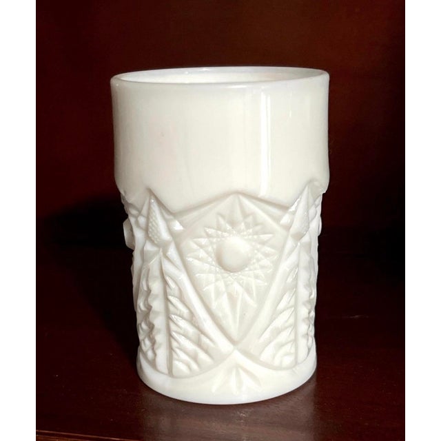 A vintage milk glass tumbler attributed to Indiana Glass Company, featuring their classic Star & Button style pressed...